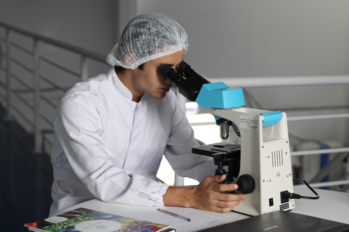 Chemist looking through microscope