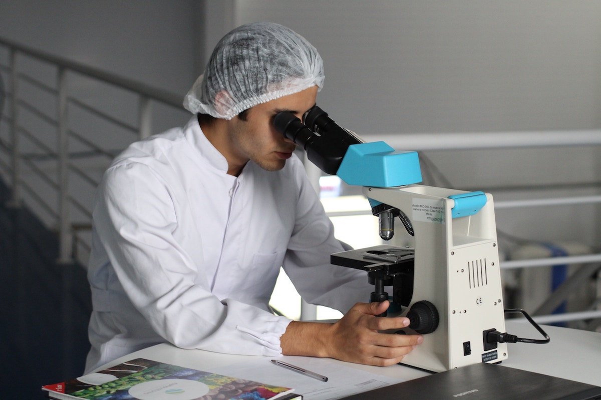 Chemist looking through microscope