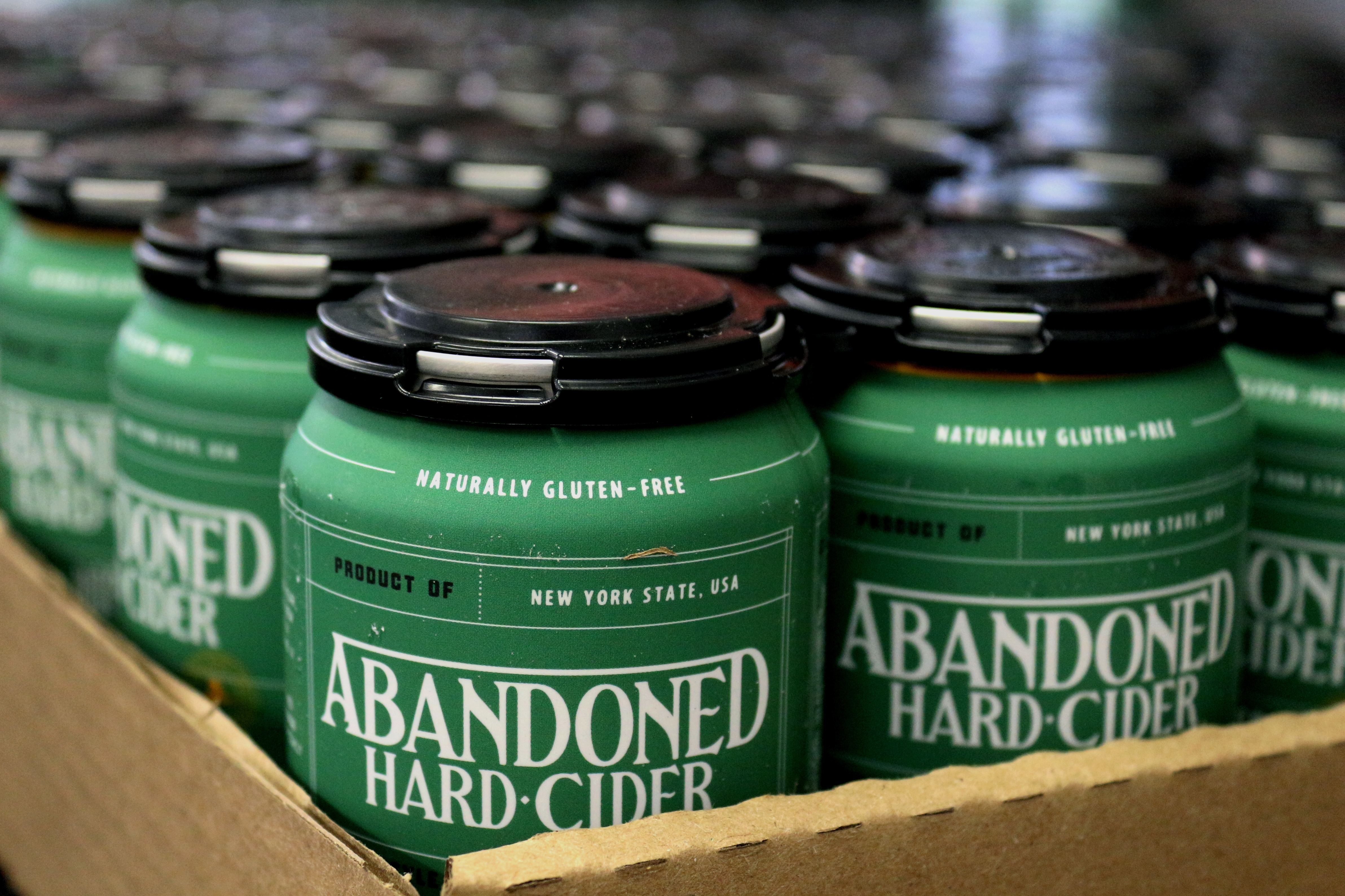 Close up of green Abandoned Hard Cider cans. 